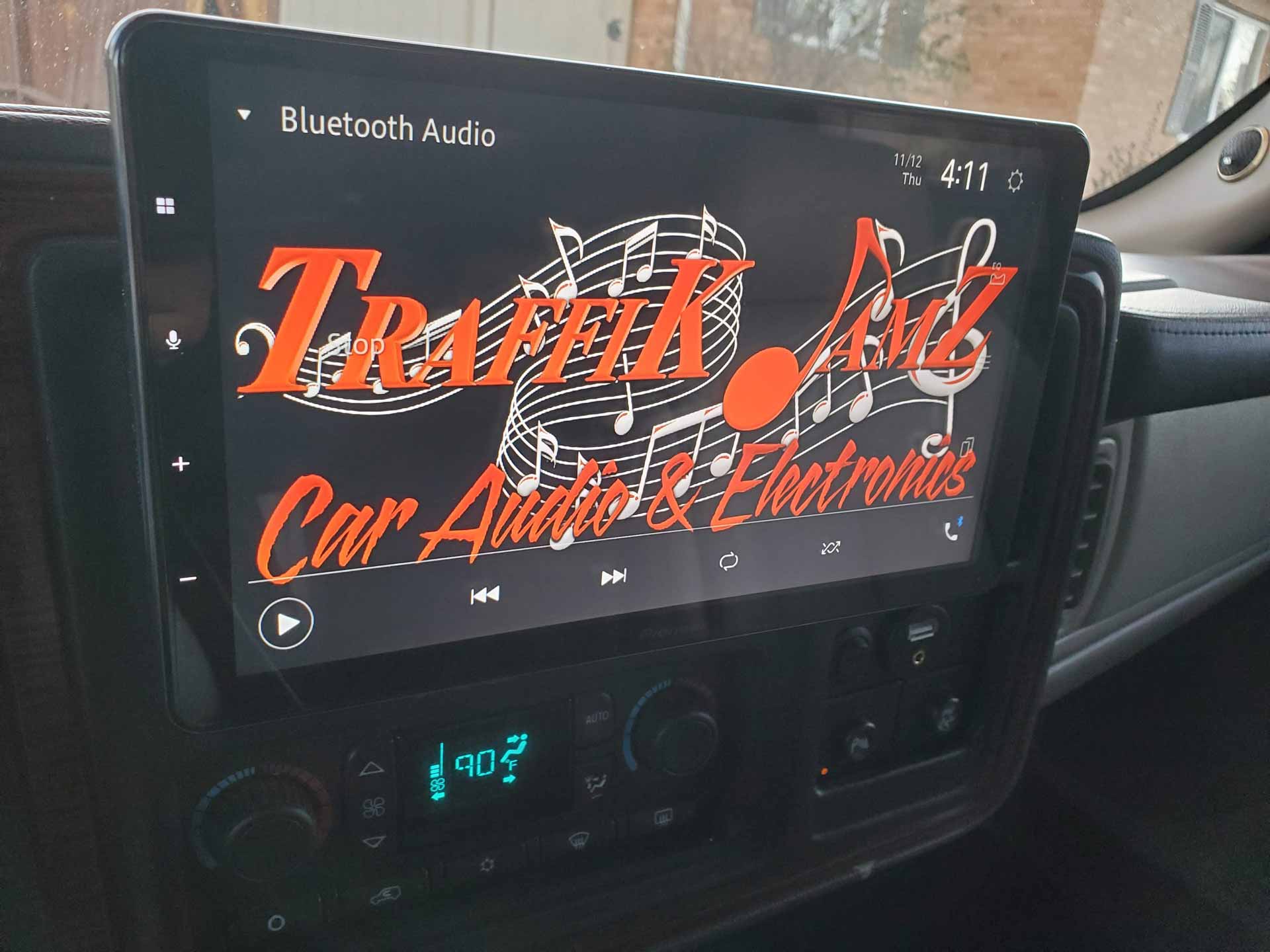In-dash touch screen installed in car, displaying the Traffic Jamz Car Audio logo
